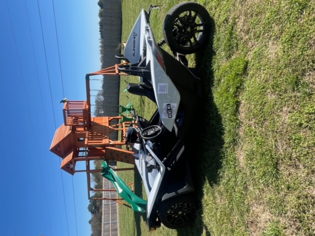 Side view of Slingshot parked on grass.